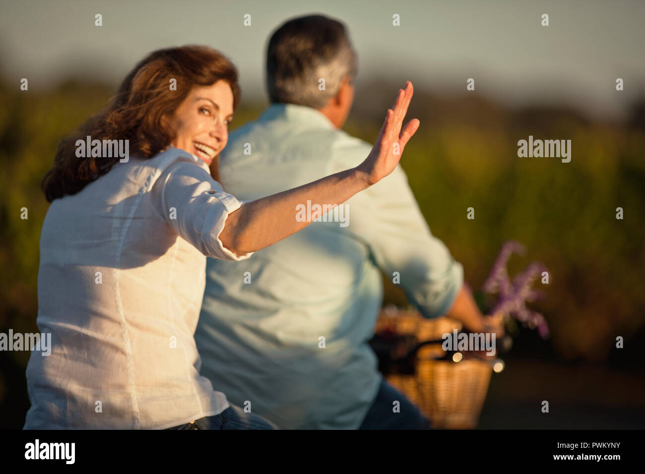 Middle-aged woman having fun riding la location avec son mari dans le vignoble. Banque D'Images