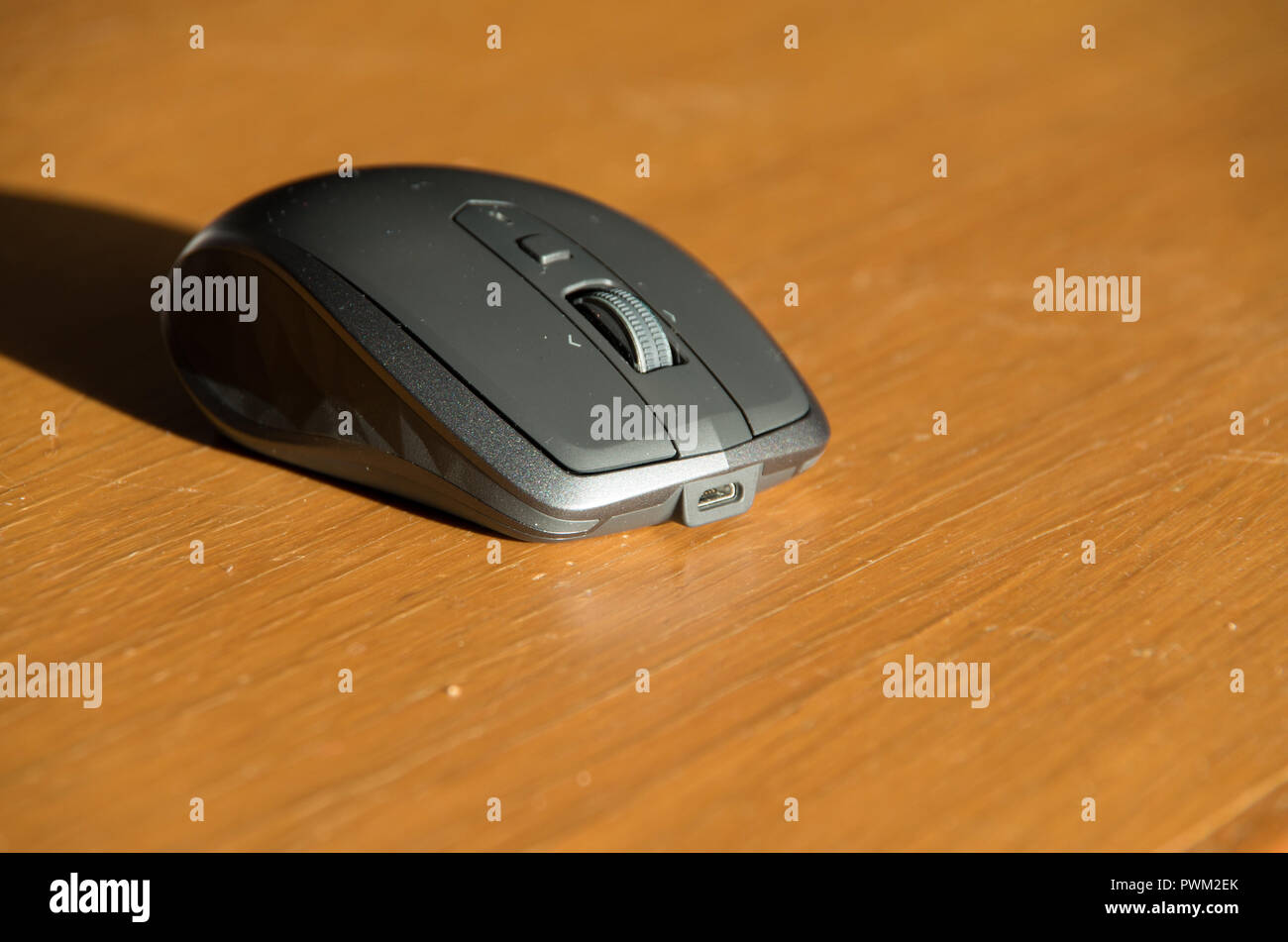 Souris sans fil omnidirectionnelle avec molette et boutons côté isolé sur une table Banque D'Images