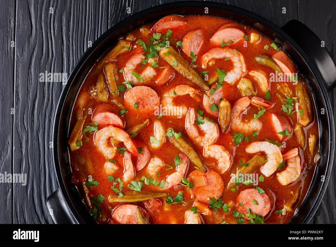Vue aérienne de gumbo classique aux gambas, les saucisses dans une cocotte sur un tableau noir, vue horizontale à partir de ci-dessus, mise à plat, close-up, macro Banque D'Images