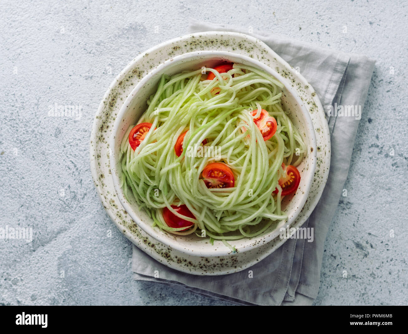 Salade de nouilles aux courgettes avec les tomates cerises. Nouilles Légumes - vert zoodles ou salade de spaghetti de courgette prête-à-manger. Nettoyer, manger la nourriture végétarienne brut concept. Copier l'espace. Vue de dessus ou de télévision. Banque D'Images