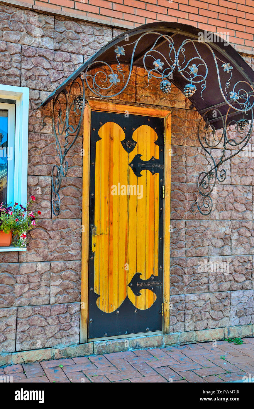 La porte en bois, décoré de forger le métal et d'auvent dans extérieur d'un  bâtiment contemporain. Éléments d'architecture pour la décoration de style  rétro Photo Stock - Alamy