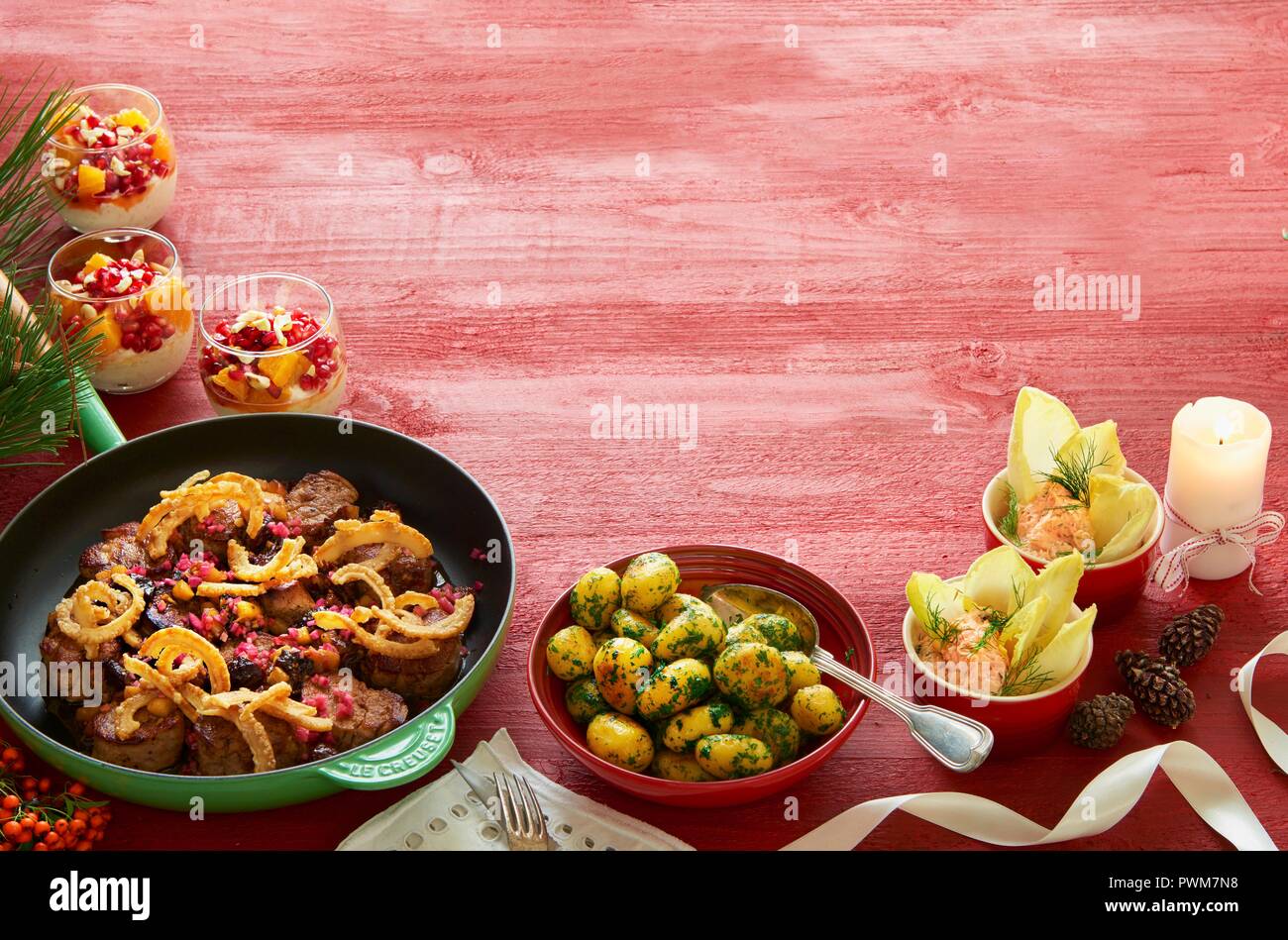 Le dîner de Noël avec médaillons de porc, pommes persillées, mousse de saumon et de crème vanille avec une salade d'orange et de pamplemousse Banque D'Images