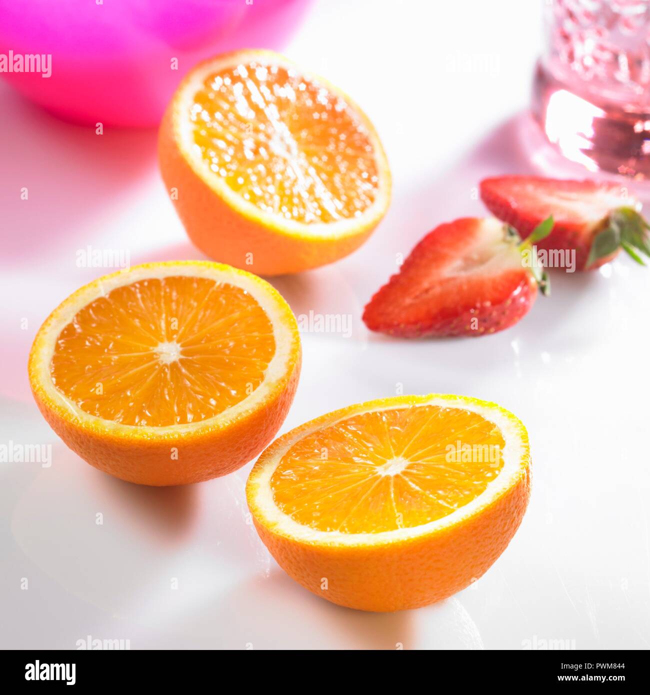 Trois moitiés d'orange et les moitiés de fraises Banque D'Images