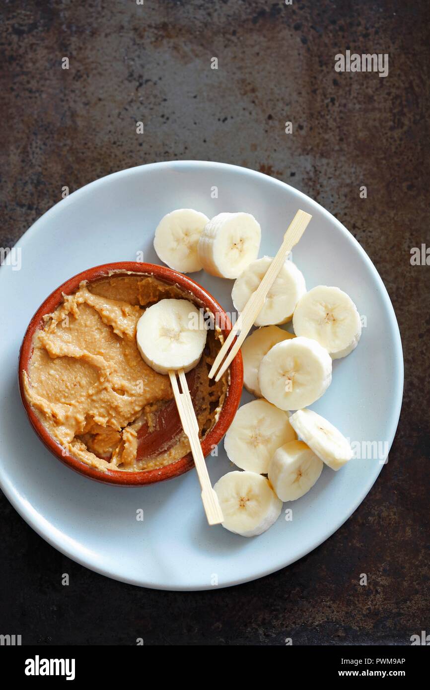 Des tranches de banane avec du beurre d'arachide pour tremper Banque D'Images