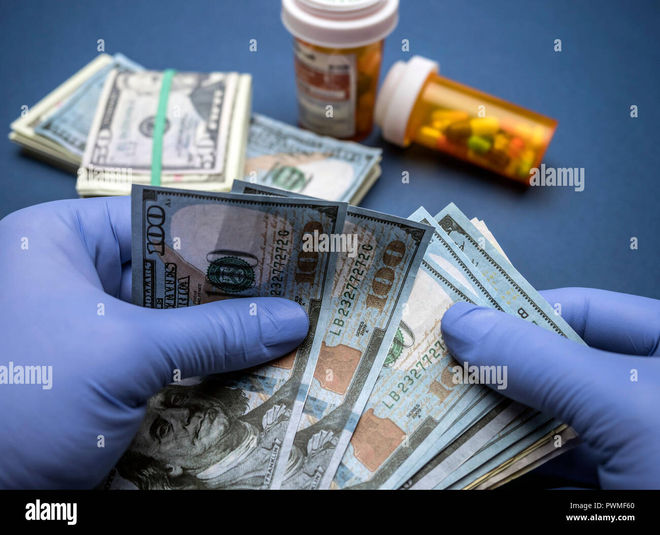 Médecin avec des gants en latex bleu compter cent billets d'un dollar dans un hôpital Banque D'Images