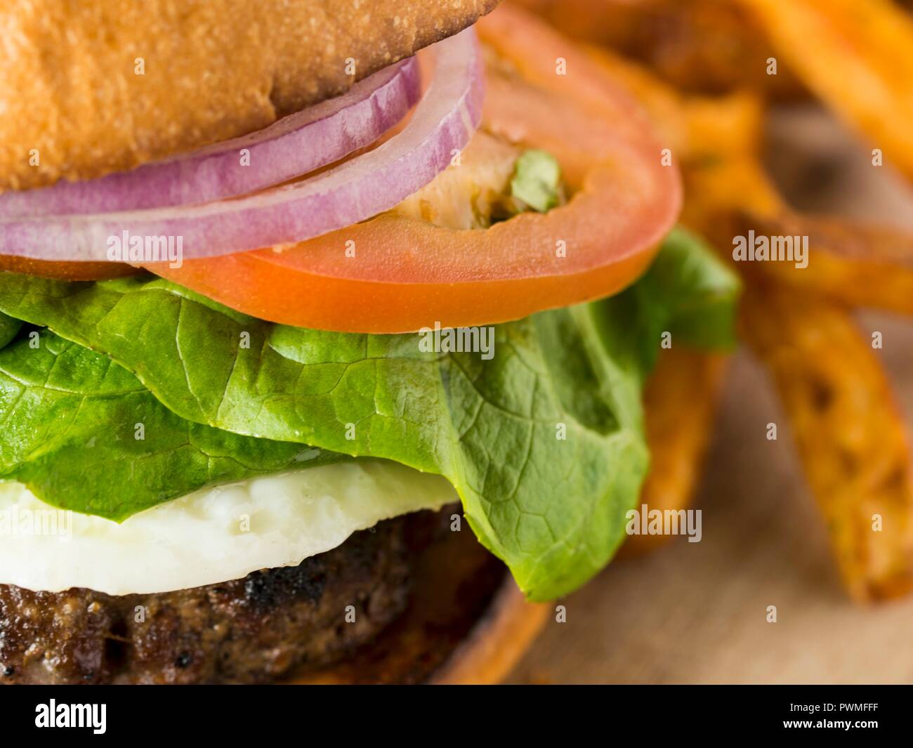 Un gros plan de la tomate, l'oignon et la laitue en hamburger Banque D'Images