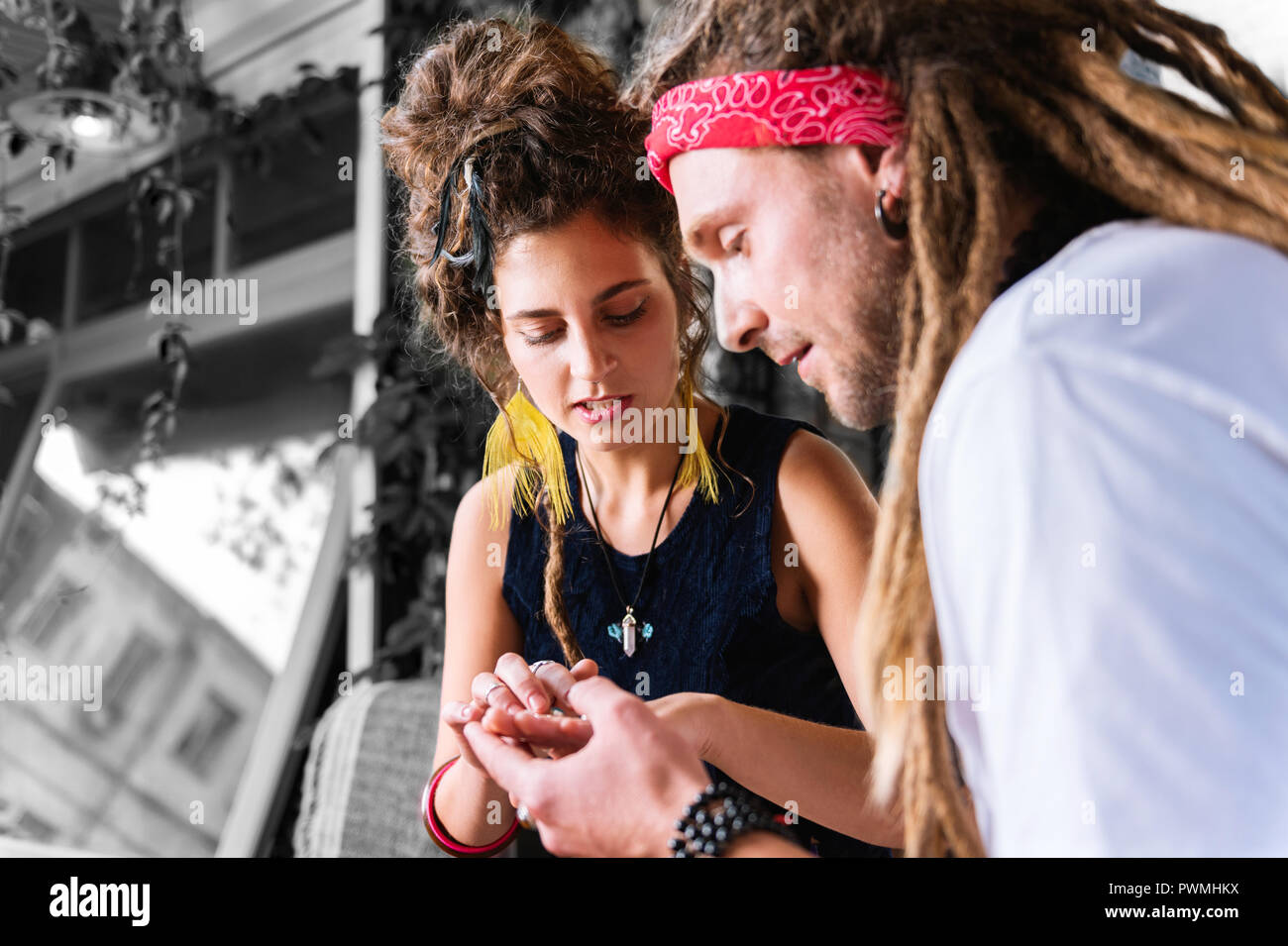 Petit ami barbu avec des dreadlocks présentant sa petite amie de nouveaux accessoires Banque D'Images