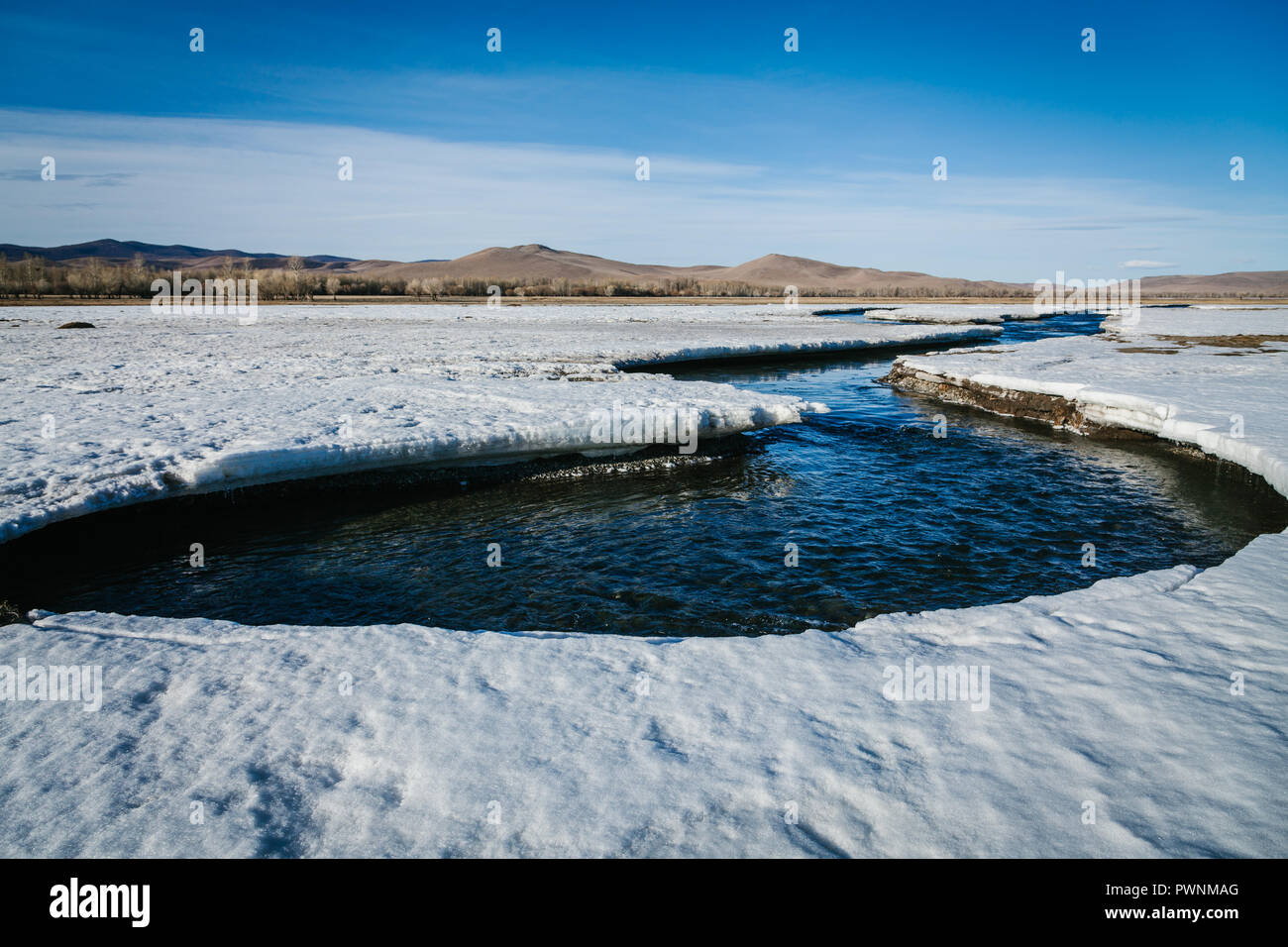 Paysage de Mongolie avec rivière décongelé récemment commencé à circuler à travers la neige et la glace. Au printemps. Mongolie, arkhangaï Banque D'Images