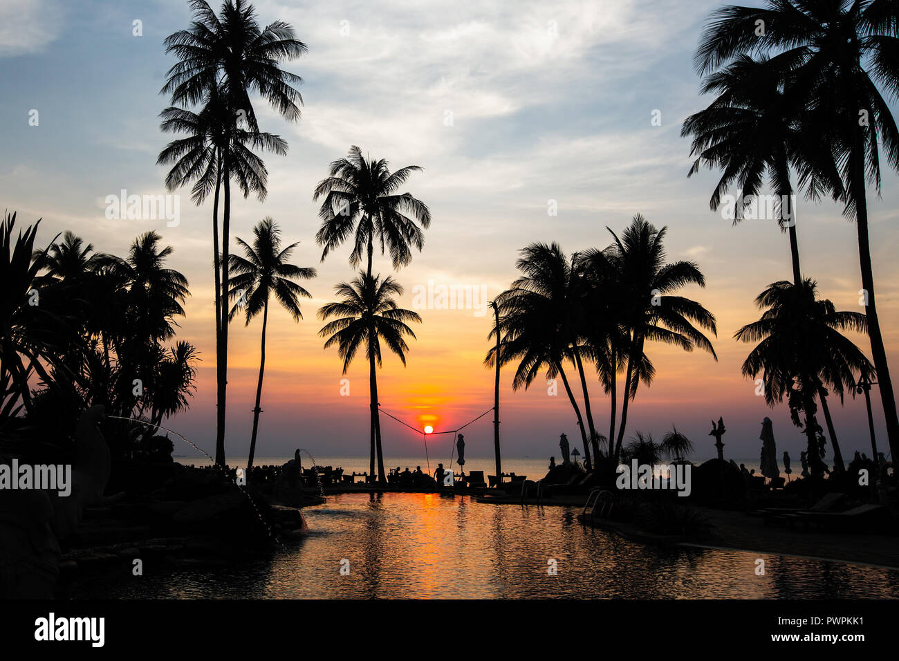 Belle plage tropicale avec palmiers silhouettes au crépuscule. Banque D'Images