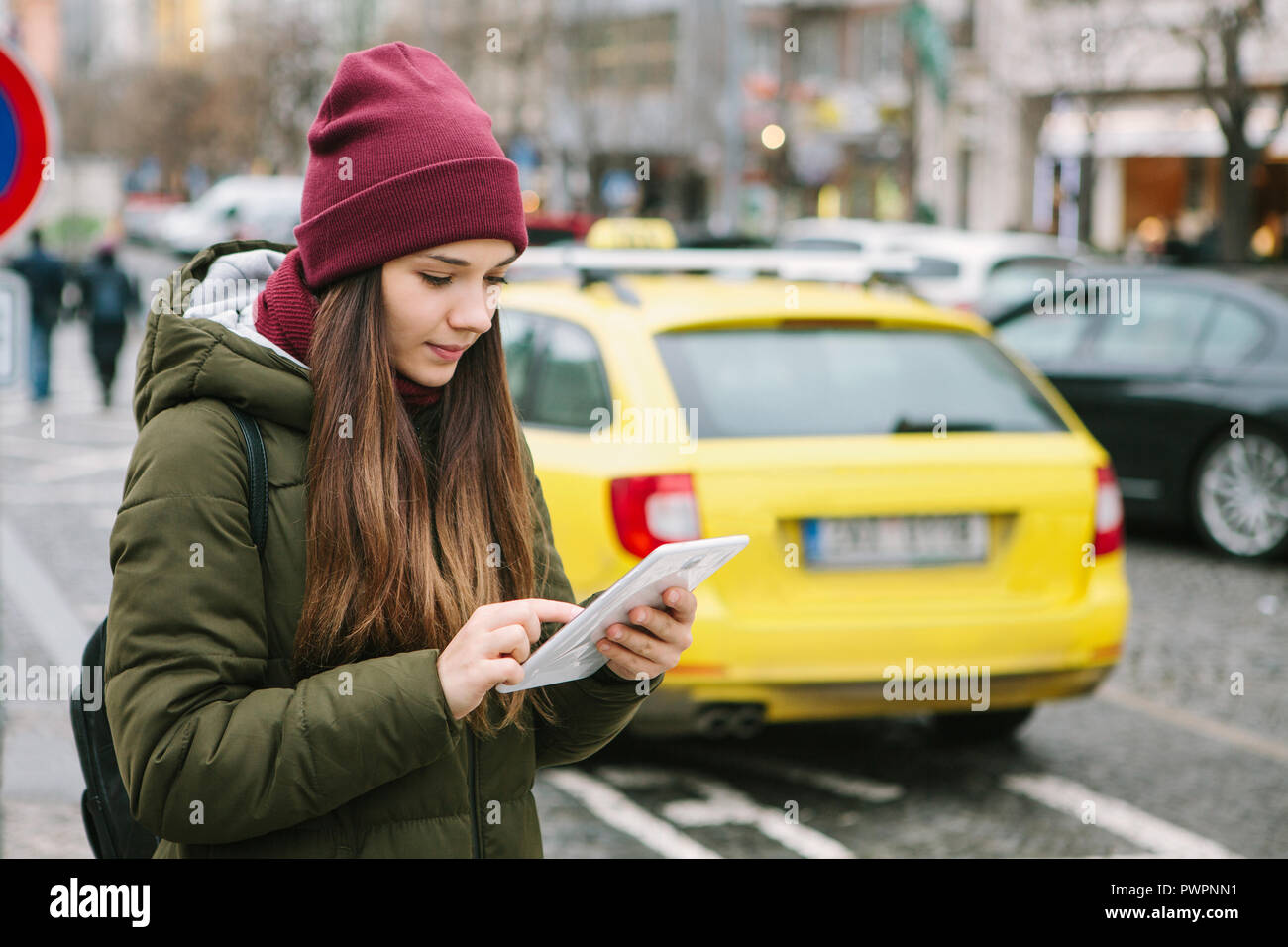 Belle fille de tourisme avec une tablette dans une rue de Prague appelle un taxi ou regarde une carte ou utilise l'Internet ou une application mobile. Le voyage ou le tourisme. Banque D'Images