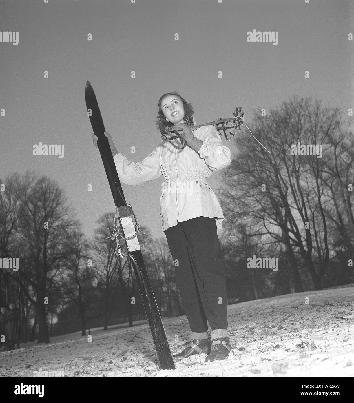L'hiver dans les années 40. Une jeune femme porte le typique des années 40, vêtements de sports d'hiver. Vêtu d'un anorak pratique, pantalon de ski et avec une paire de skis et bâtons. Suède 1948. Kristoffersson Photo ref Y10-4 Banque D'Images