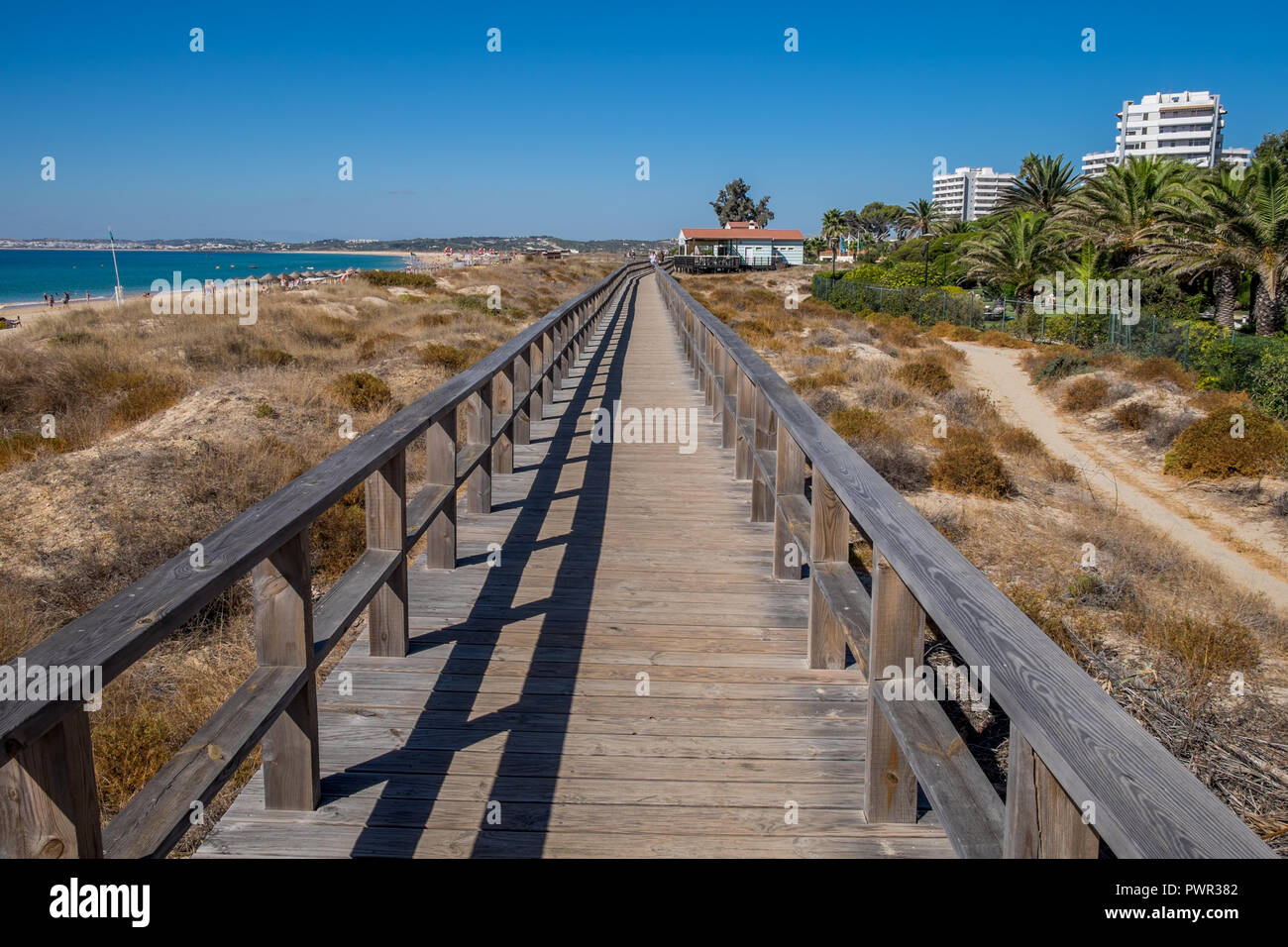 Promenade menant à la plage avec quelques chaises longues. Banque D'Images