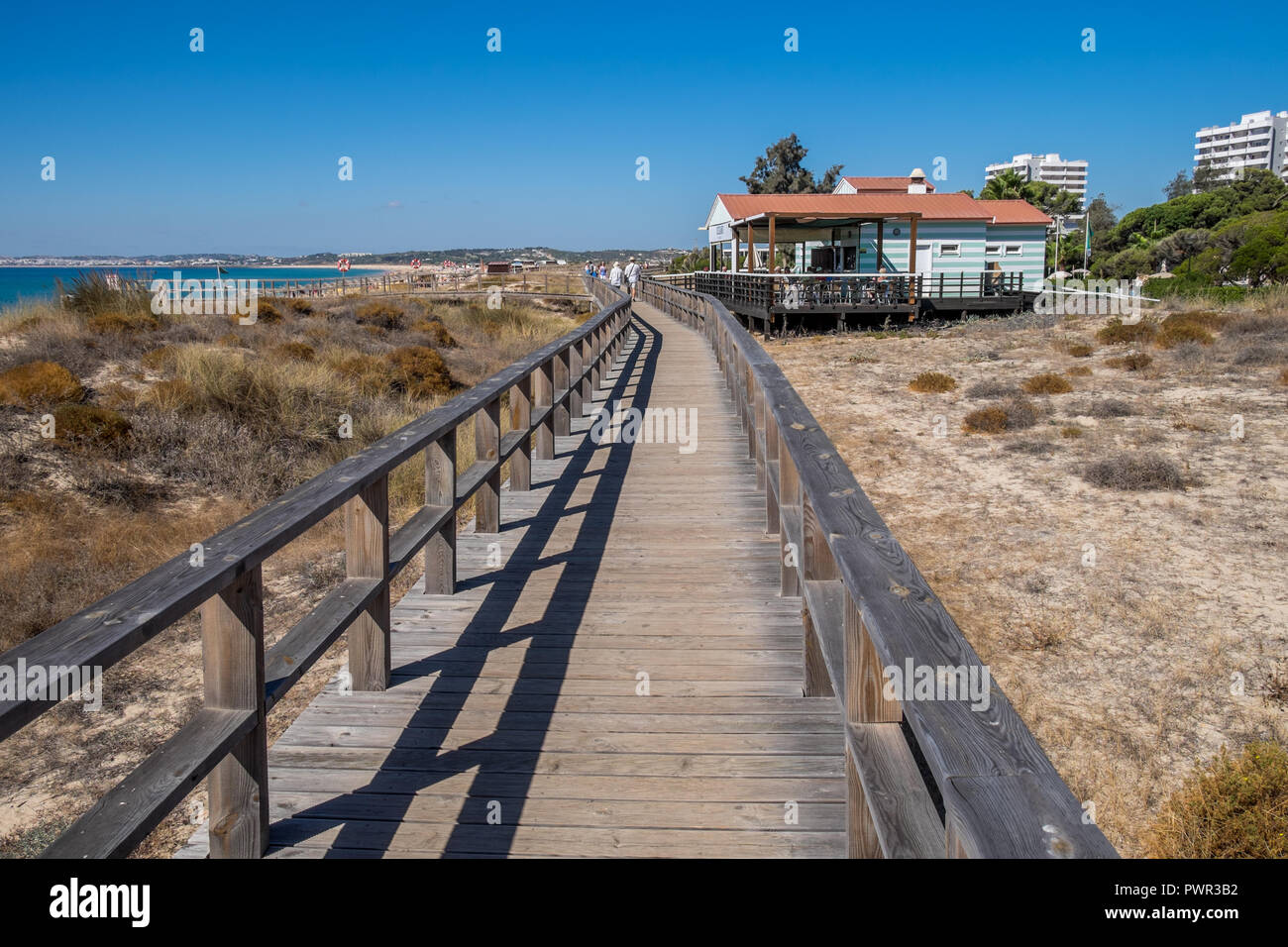 Promenade menant à la plage avec quelques chaises longues. Banque D'Images