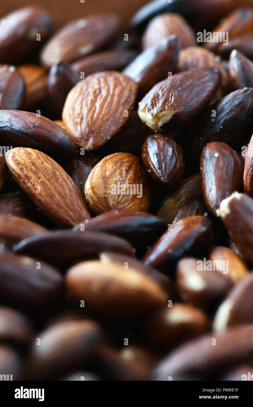 En verticale de l'image de plein cadre organique saine amandes torréfiées cuit au sel et d'huile d'olive, tourné en focus sélectif d'estomper l'arrière-plan pour le texte Banque D'Images