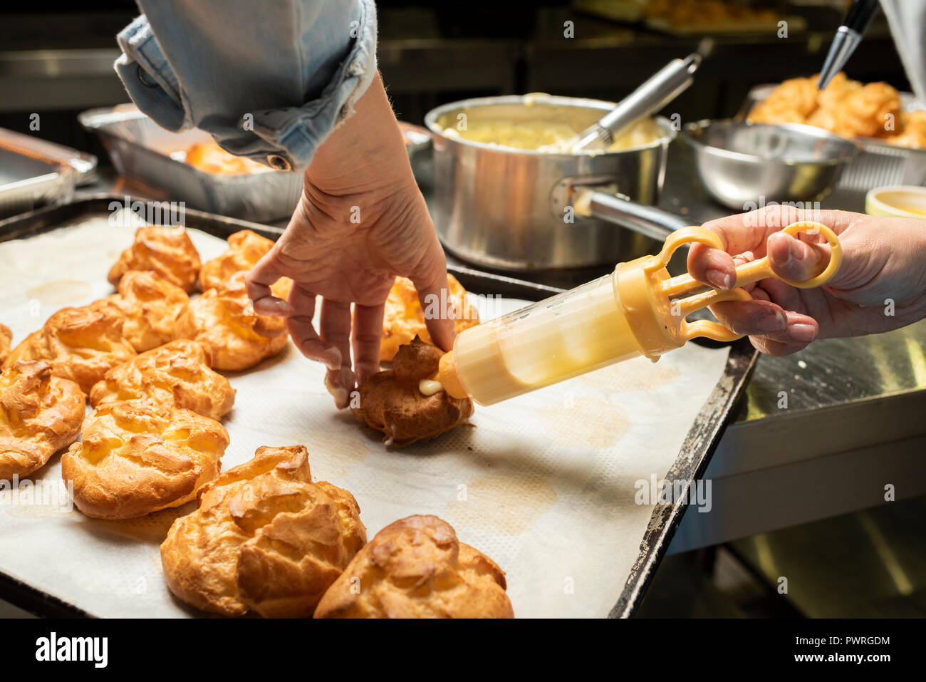 Le remplissage avec un seringue éclairs confiseries avec des mains Banque D'Images