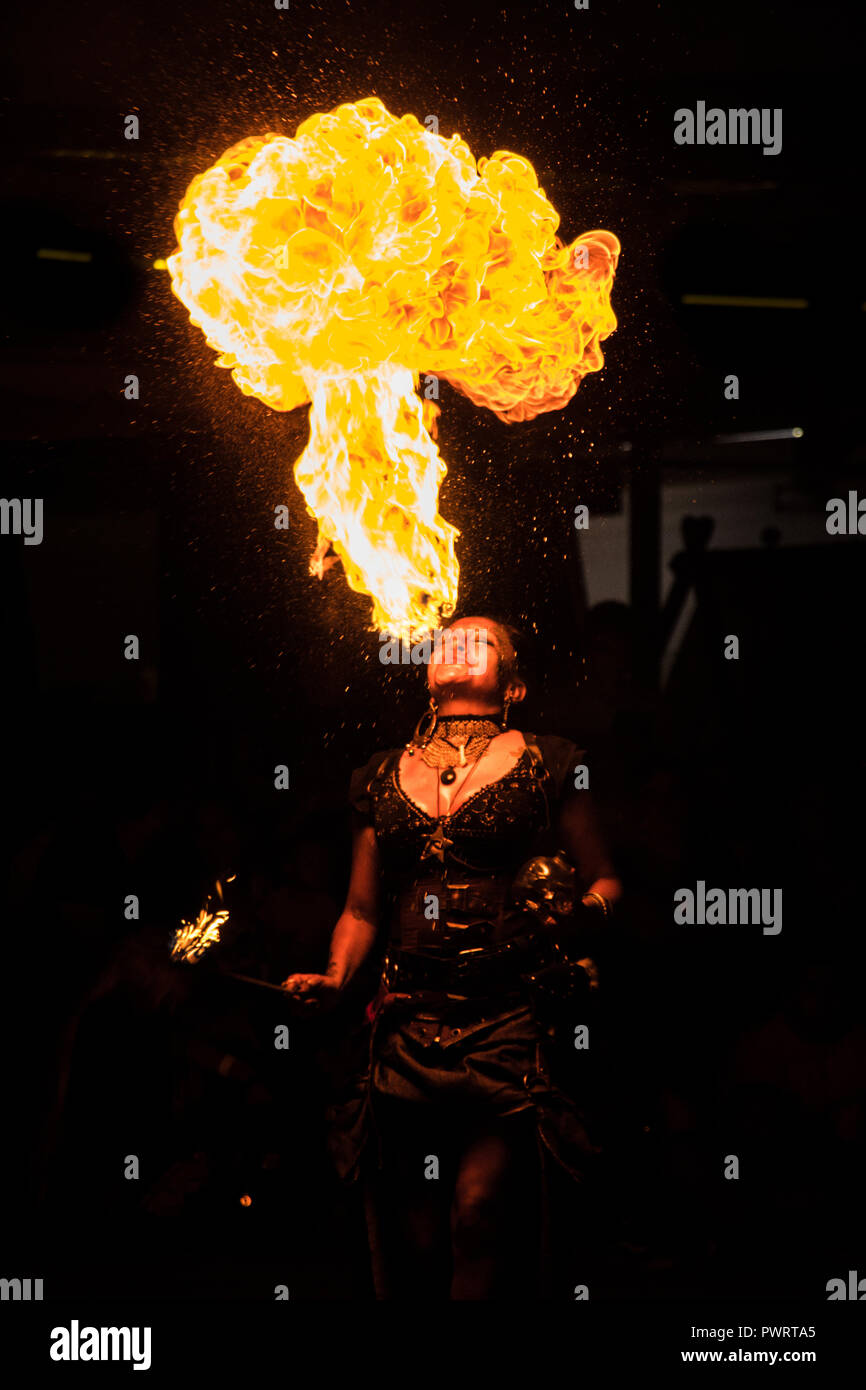 Cracheuse de feu dans la nuit montrent au festival médiéval sur fond noir Banque D'Images