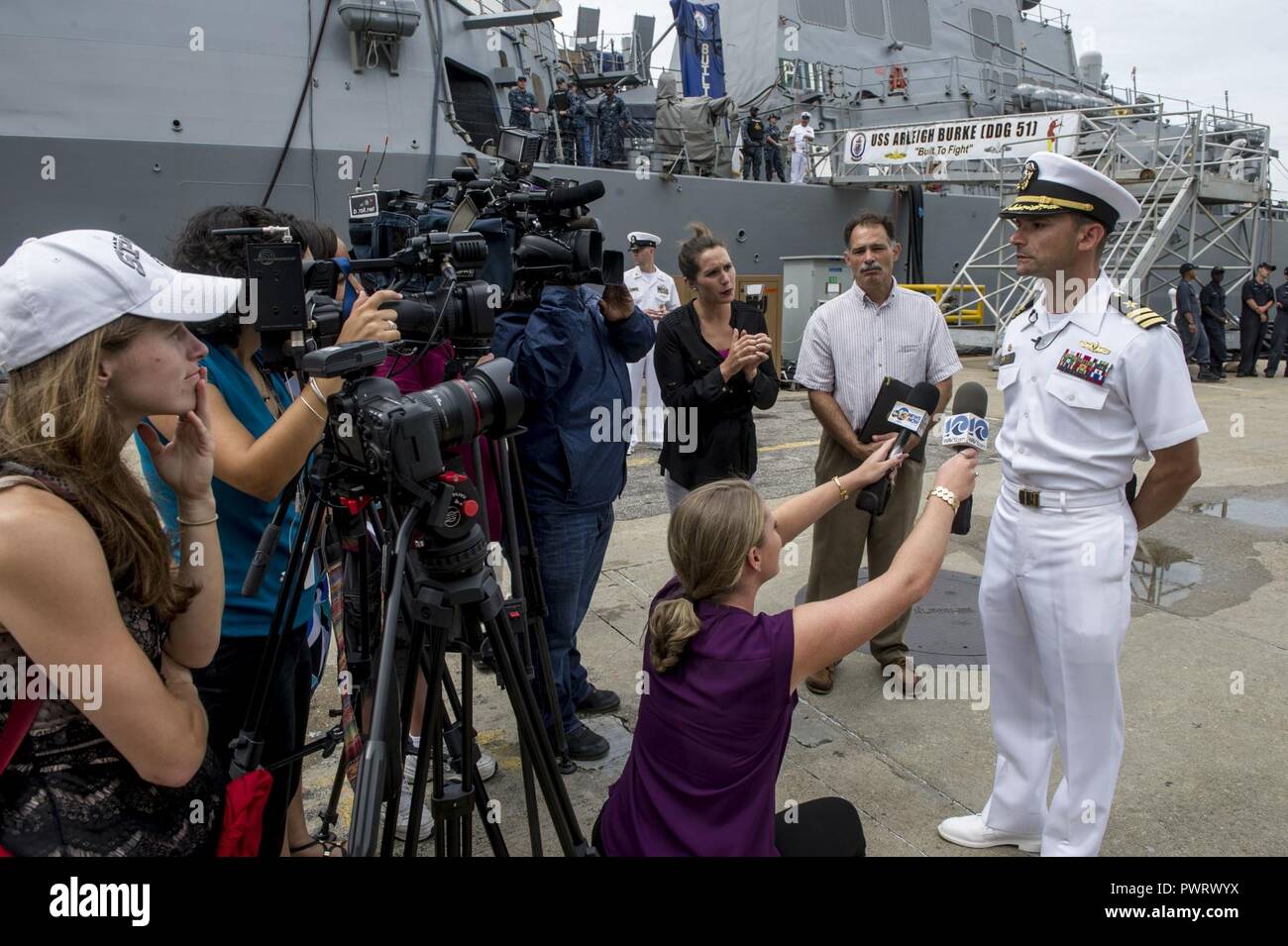 La NORFOLK (sept. 20, 2017) Le Cmdr. Marc Davis, commandant de l'destoryer-missiles USS Mahan (DDG 72), parle aux médias locaux après le retour du navire d'un déploiement de sept mois à partir de la 5e flotte américaine zone d'opérations. L'équipage du navire a mené 24 Détroit d'Ormuz, transits 25 ravitaillement en mer et 50 des exercices d'armes avec 53 opérations de sauvetage de petites embarcations à l'appui d'opérations de sécurité maritime dans le théâtre Banque D'Images