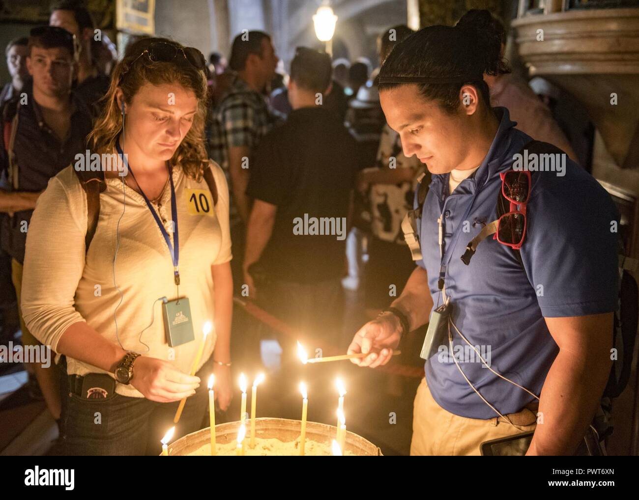 Jérusalem (3 juillet 2017) Le Lieutenant Jennifer Groger (gauche) de la 'Tridents' de la mer d'hélicoptères de l'Escadron de Combat (HSC) 9 et Justin Vigile, le patron de remise en forme à bord du porte-avions USS George H. W. Bush (CVN 77) allumer une bougie dans l'église du Saint-Sépulcre. Le navire est à Haïfa, en Israël pour une visite de port prévue pour améliorer les relations entre les États-Unis et Israël. ( Banque D'Images