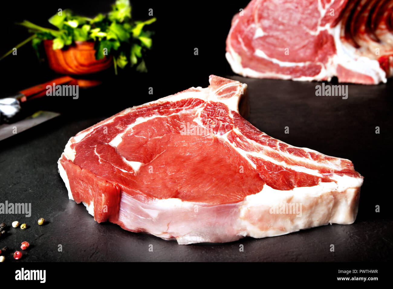 Les viandes fraîches et hachez Raw steak sur fond noir de l'ardoise noire. Les viandes rôties et grillées. Installations pour Barbecue Banque D'Images
