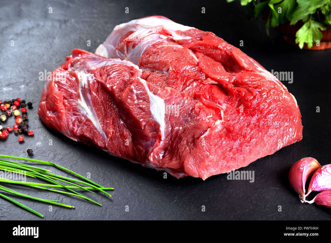 Produits frais et de la viande crue. La vie encore de viande rouge steak prêt à cuire sur le barbecue. Fond d'ardoise noire Banque D'Images