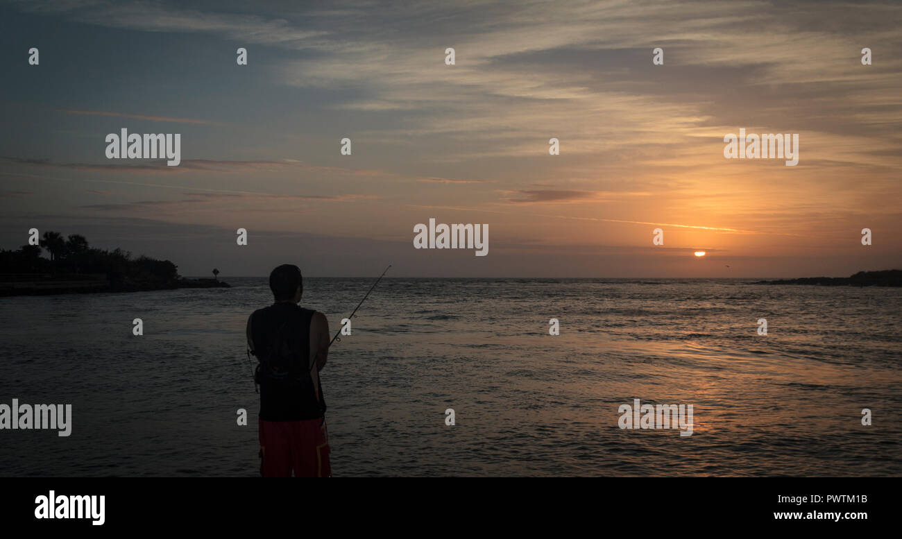 Silhouette d'un homme de la jetée de pêche à Sunset Park, St Pete Beach, Floride Banque D'Images