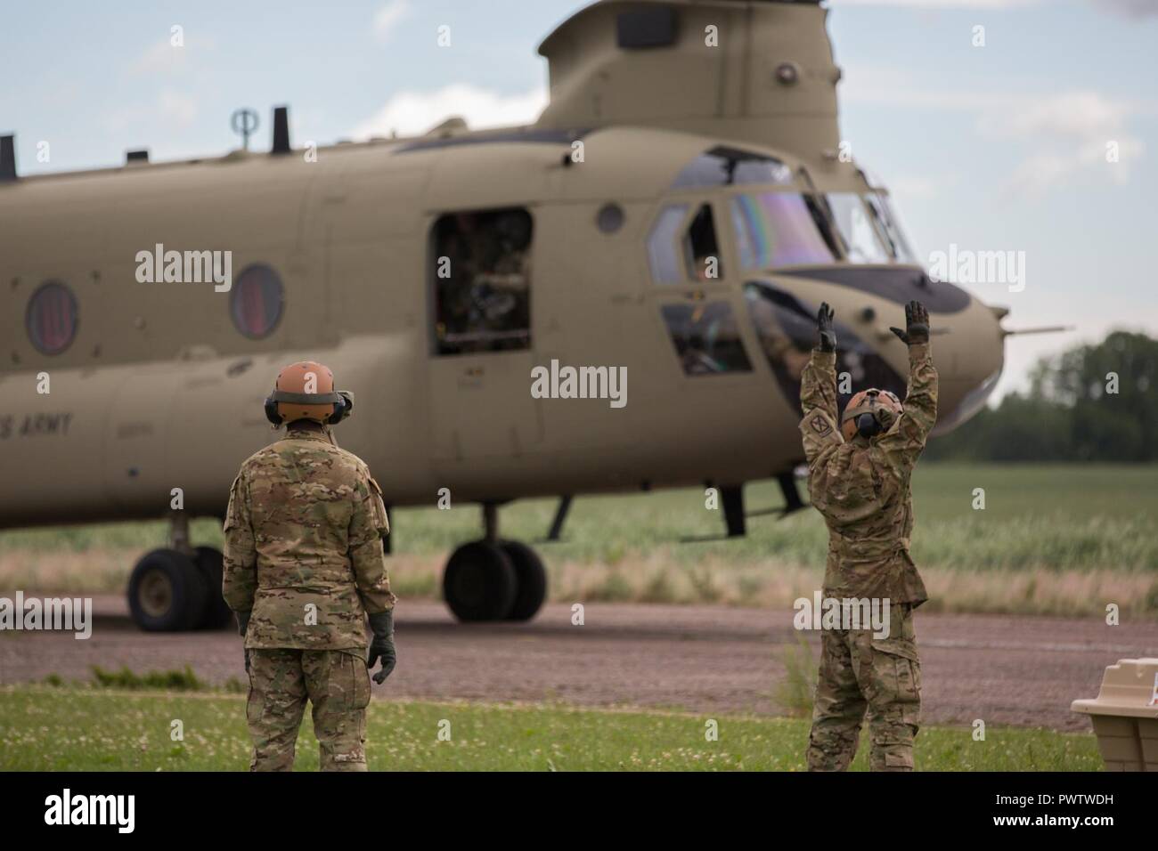 Les soldats de l'armée américaine un guide CH-47 Chinook sur la piste pendant la grève à Pabrade sabre 17, la Lituanie, le 22 juin 2017. Grève 17 Sabre de l'armée américaine est une force multinationale de l'Europe exercer des forces combinées menée chaque année pour renforcer l'Alliance de l'OTAN dans la région de la Baltique et de la Pologne. L'exercice de cette année comprend et intégré de formation axés sur la dissuasion synchronisé conçu pour améliorer l'interopérabilité et à l'état de préparation des forces militaires des Nations Unies participantes 20. Banque D'Images