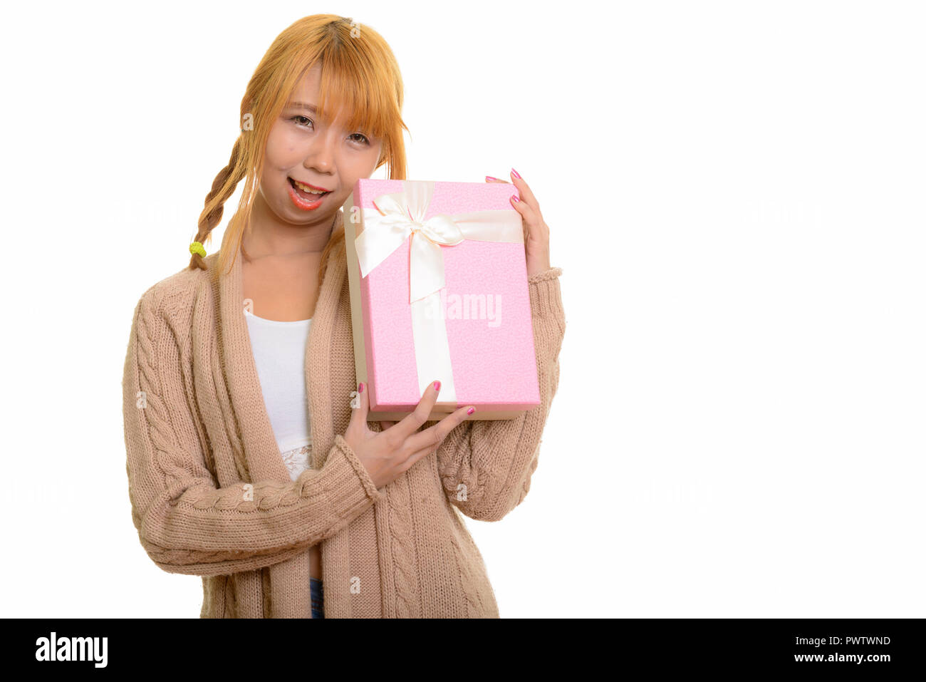 Young happy Asian woman smiling and holding gift box Banque D'Images