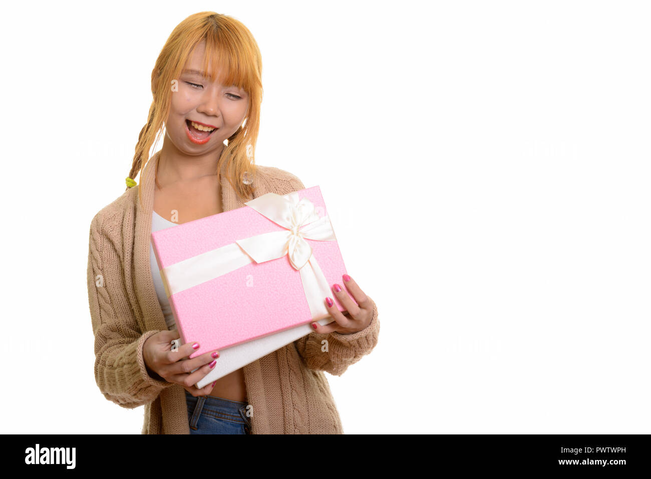 Young happy Asian woman smiling et ouverture de boîte-cadeau Banque D'Images
