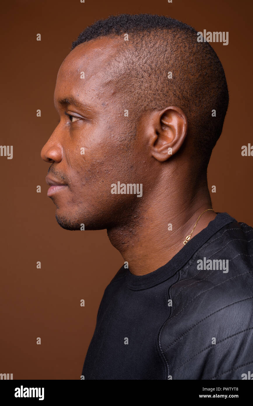 Portrait de jeune homme africain contre fond brun Banque D'Images