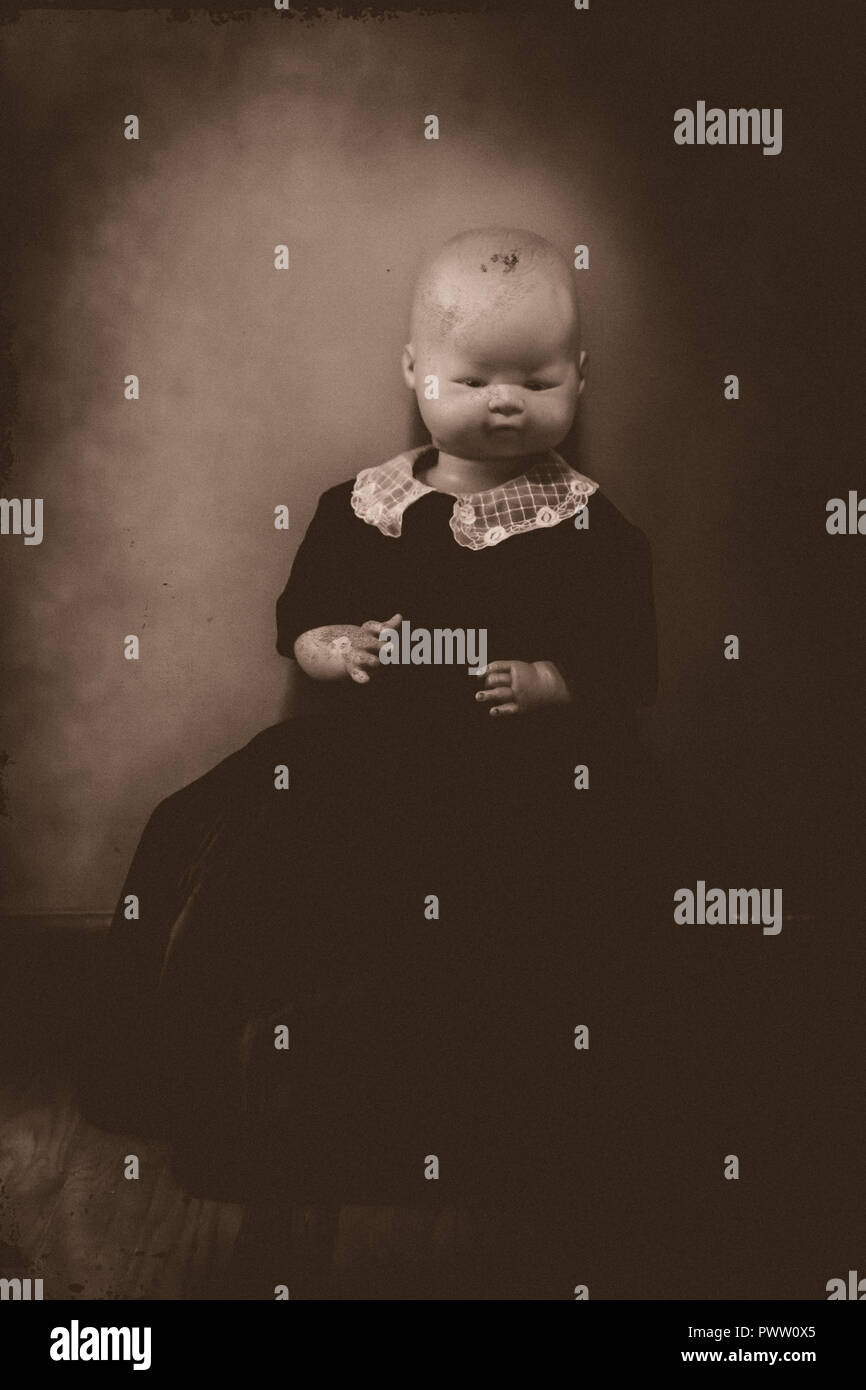 Un portrait d'un vieux creepy doll, ressemblant à un bébé posé. L'image est fait pour ressembler à une vieille photographie. Banque D'Images