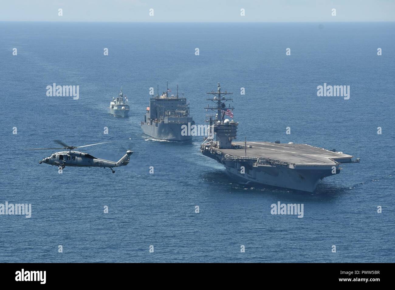 Océan Atlantique (27 juin 2017) Un MH-60S Sea Hawk affecté à la 'Dusty' Chiens de mer d'hélicoptères de l'Escadron de Combat (HSC) 7 défile le porte-avions USS Dwight D. Eisenhower (CVN 69, le navire de munitions et de marchandises sèches USNS Robert E. Perry (T-AKE 5) et de la Marine royale canadienne frégate NCSM Charlottetown (FFH 339) au cours de l'exercice d'une photo. Dwight D. Eisenhower est en cours d'un groupe bilatéral de la voile dans le cadre de la célébration de l'anniversaire du Canada 150. ( Banque D'Images