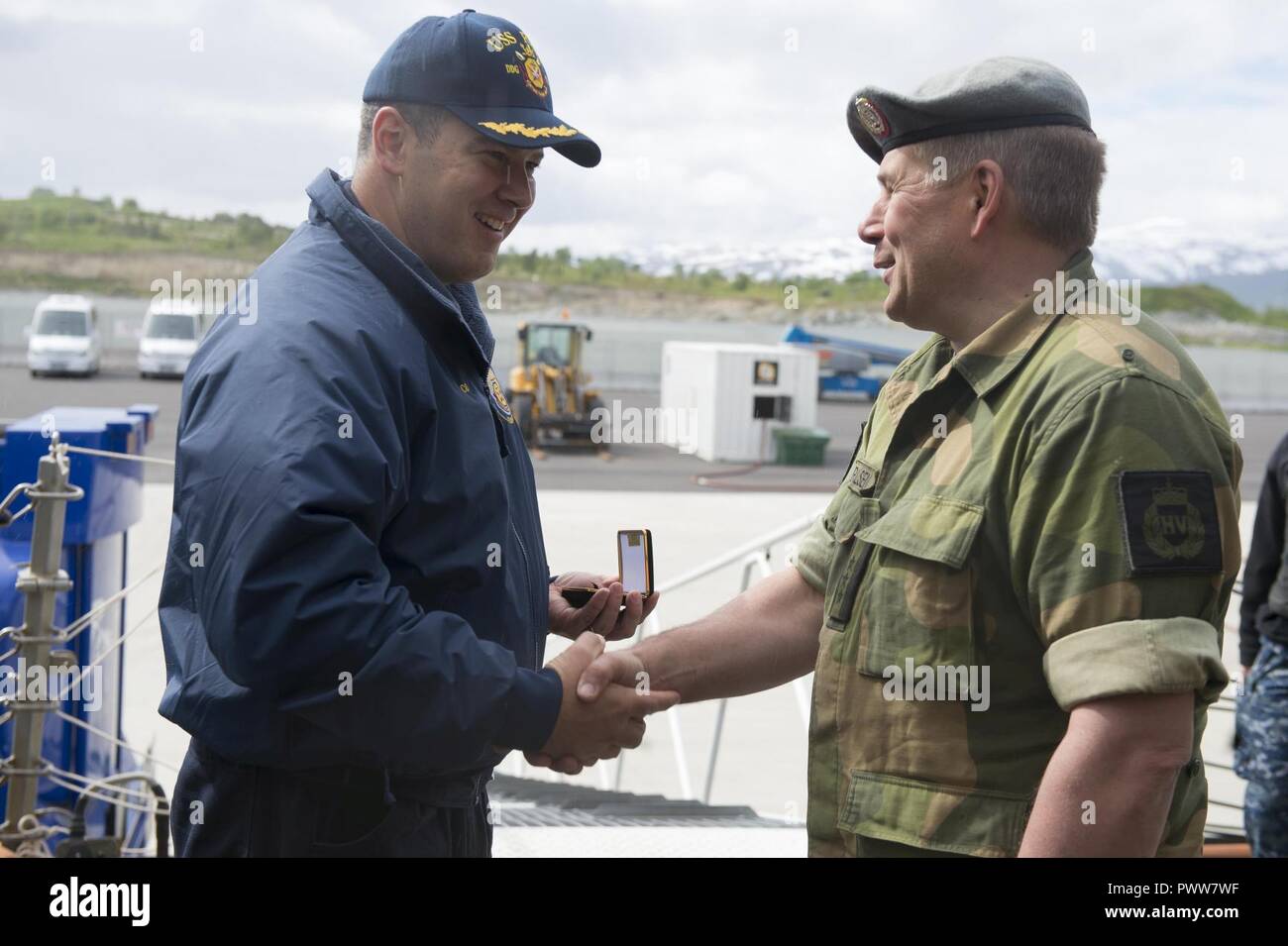TROMSØ, NORVÈGE (28 juin 2017) Le Cmdr. Bryan Gallo, commandant de la classe Arleigh Burke destroyer lance-missiles USS Ross (DDG 71), gauche, échange de cadeaux avec un fonctionnaire de la Home Guard norvégien, District 16, tandis que la location à Tromsø, Norvège, le 28 juin 2017. Ross, l'avant-déployé à Rota, Espagne, mène des opérations navales dans la sixième flotte américaine zone d'opérations à l'appui de la sécurité nationale des États-Unis en Europe et en Afrique. ( Banque D'Images