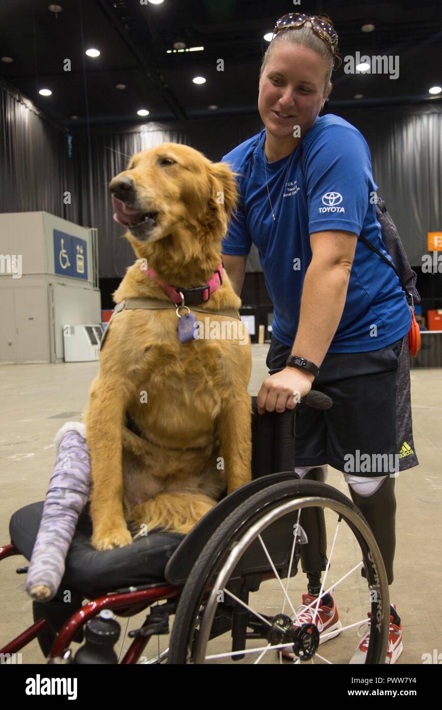 Vétéran de l'armée américaine de la CPS. Christina Gardner, à partir de Fort Campbell, Kentucky, montres son chien aidant pendant la brève bienvenue pour le ministère de la Défense 2017 Warrior Jeux à Chicago, Illinois, le 29 juin 2017. La DOD Warrior Jeux sont un événement annuel permettant aux blessés, malades et blessés militaires et anciens combattants au style paralympiques sports comme le tir à l'arc, randonnée à vélo, terrain, tir, le volleyball assis, natation, athlétisme et de basket-ball en fauteuil roulant. Banque D'Images