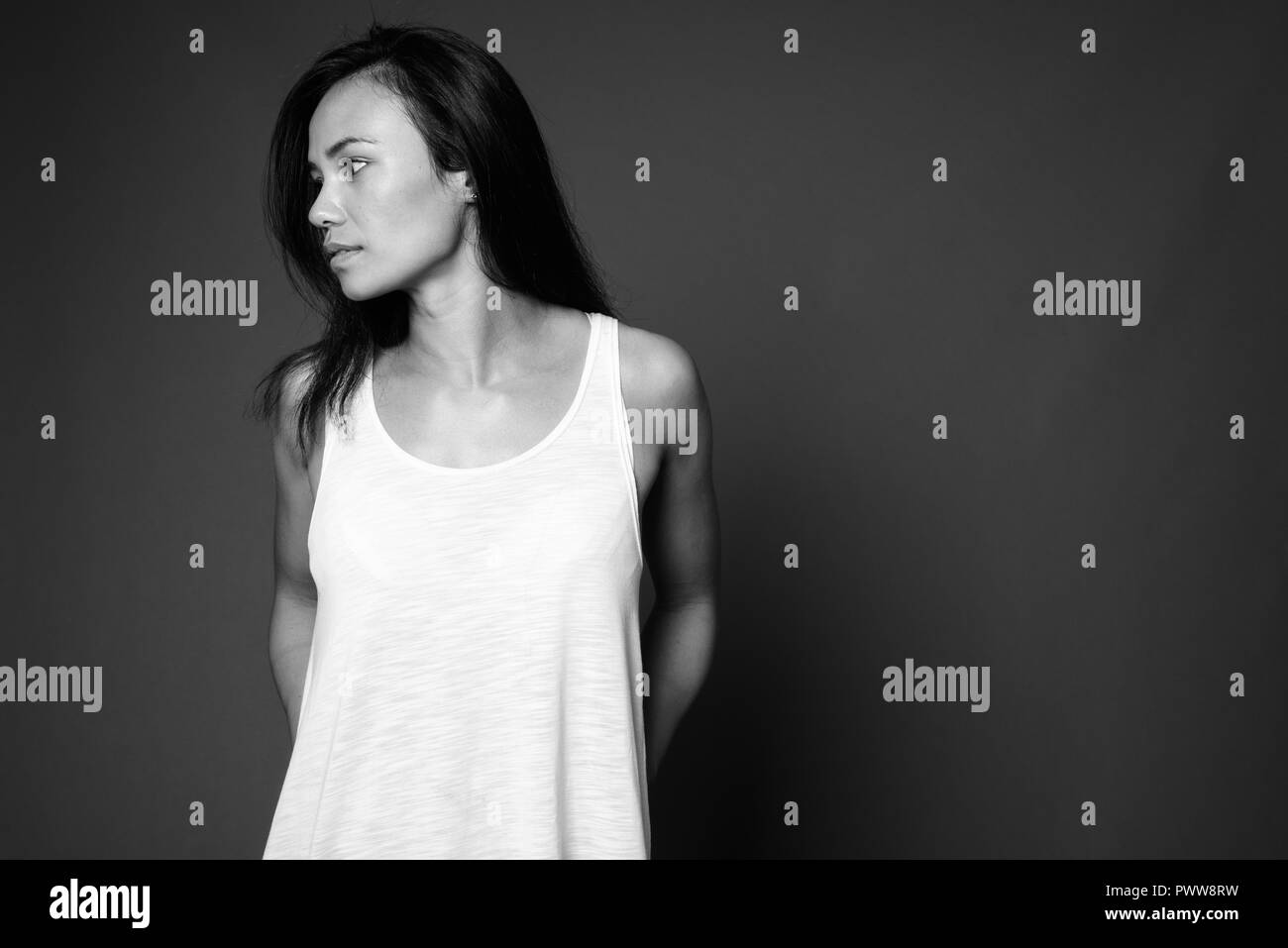 Young Asian woman contre l'arrière-plan gris en noir et blanc Banque D'Images