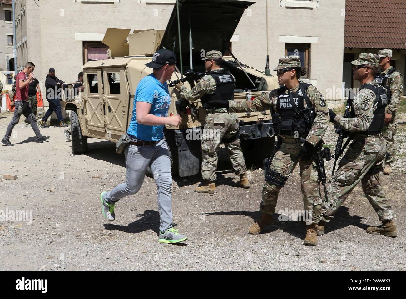 Les civils rôle joué par la 45e Brigade d'infanterie de l'équipe de combat de l'Army National Guard Oklahoma courir à la Police militaire en quête de sécurité au cours d'un scénario de formation de tir le 28 juin 2017 à JMRC en Hohenfels, Allemagne. La 591e compagnie MP, 93e Bataillon, MP MP 89e Brigade à Fort Bliss, au Texas est la formation en préparation de leur MNBG-e mission de sécurité. Banque D'Images