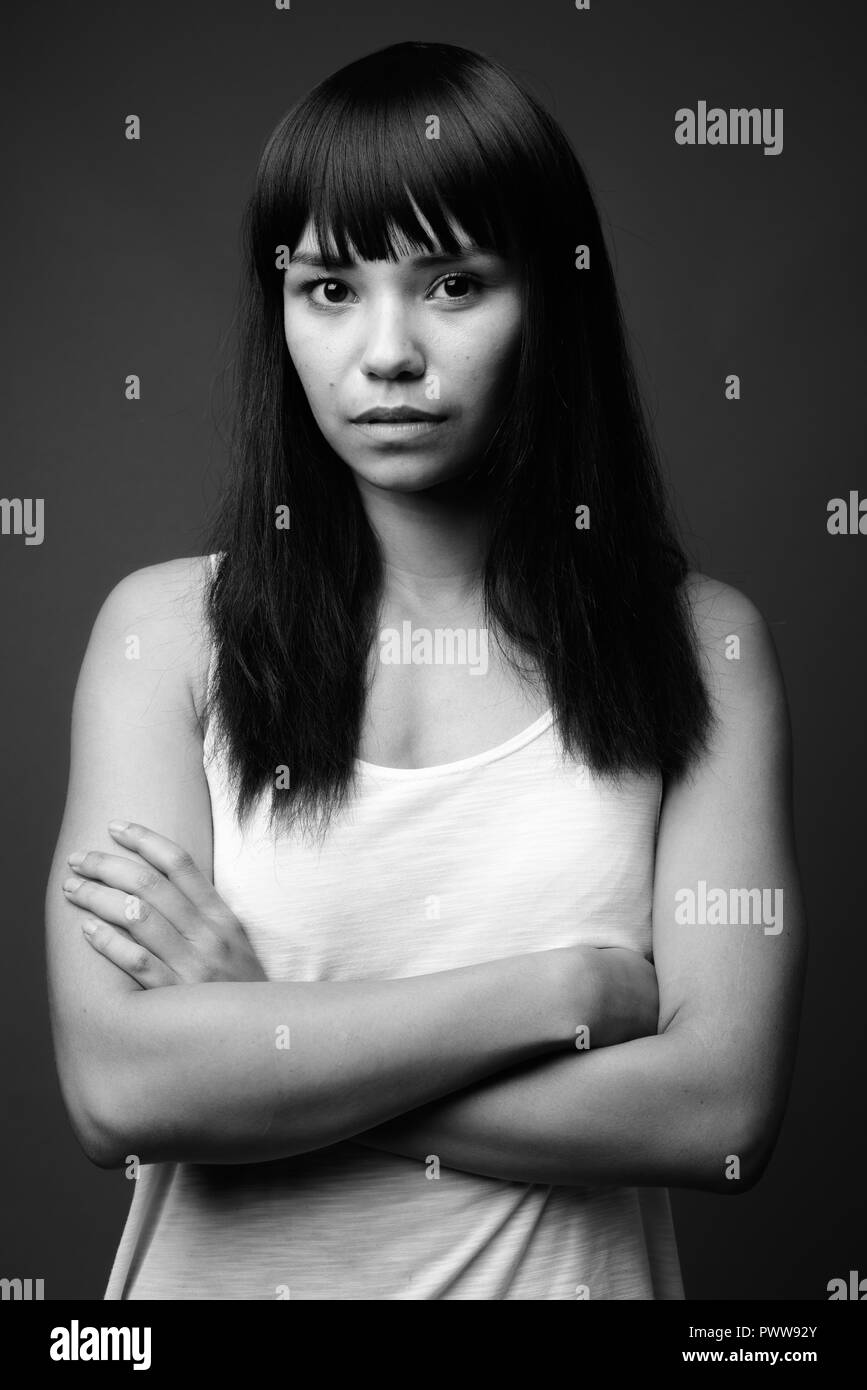 Young Asian woman contre l'arrière-plan gris en noir et blanc Banque D'Images