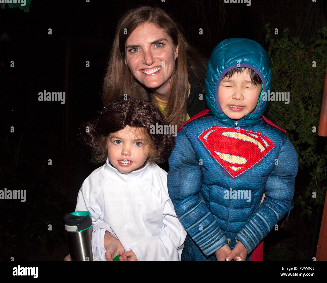 Maman avec ses trucs et astuces Halloween ou traite de Supergirl et Princesse Leia personnages en costume. St Paul Minnesota MN USA Banque D'Images