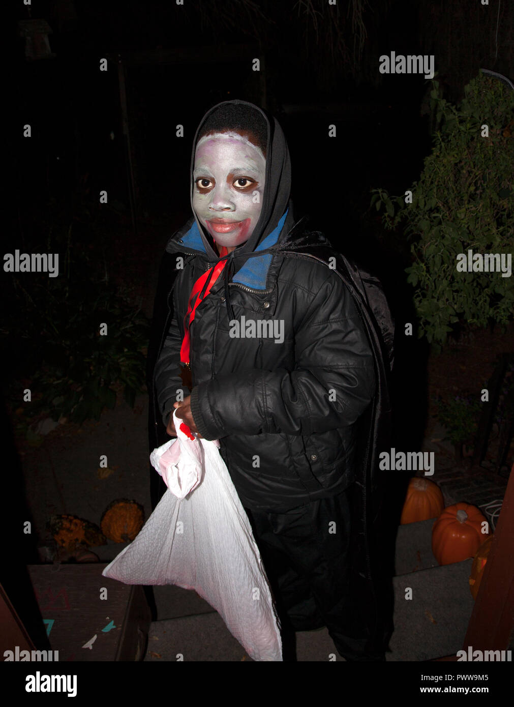 Portrait of African American' Halloween ou comme une goule effrayante face blanche en espérant pour un chargement de bonbons dans son sac. St Paul Minnesota MN USA Banque D'Images