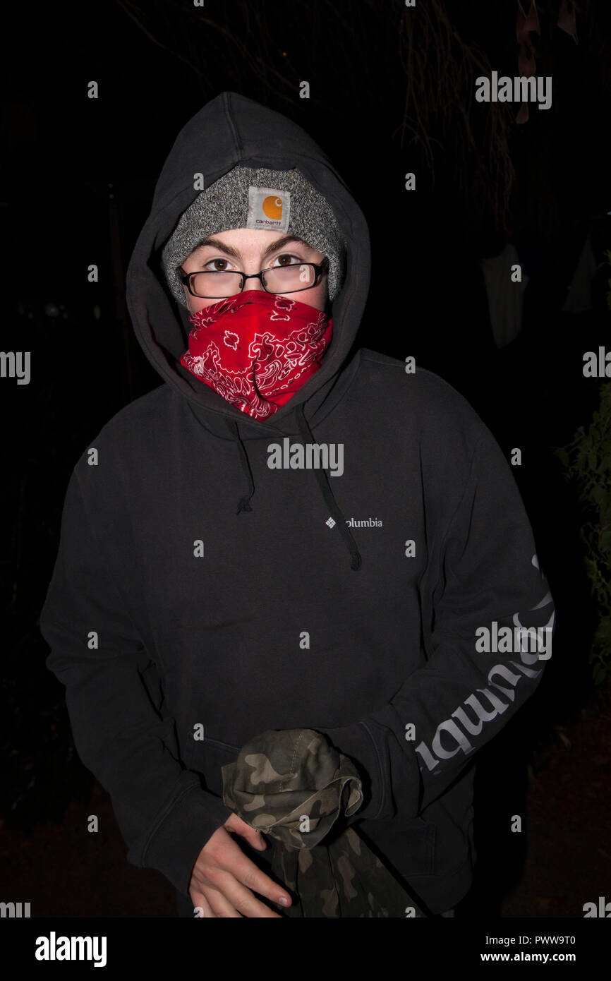 Trucs et astuces Halloween' ou en voleur bandit avec bandana sur bouche portant une veste chaude, par une nuit froide. St Paul Minnesota MN USA Banque D'Images