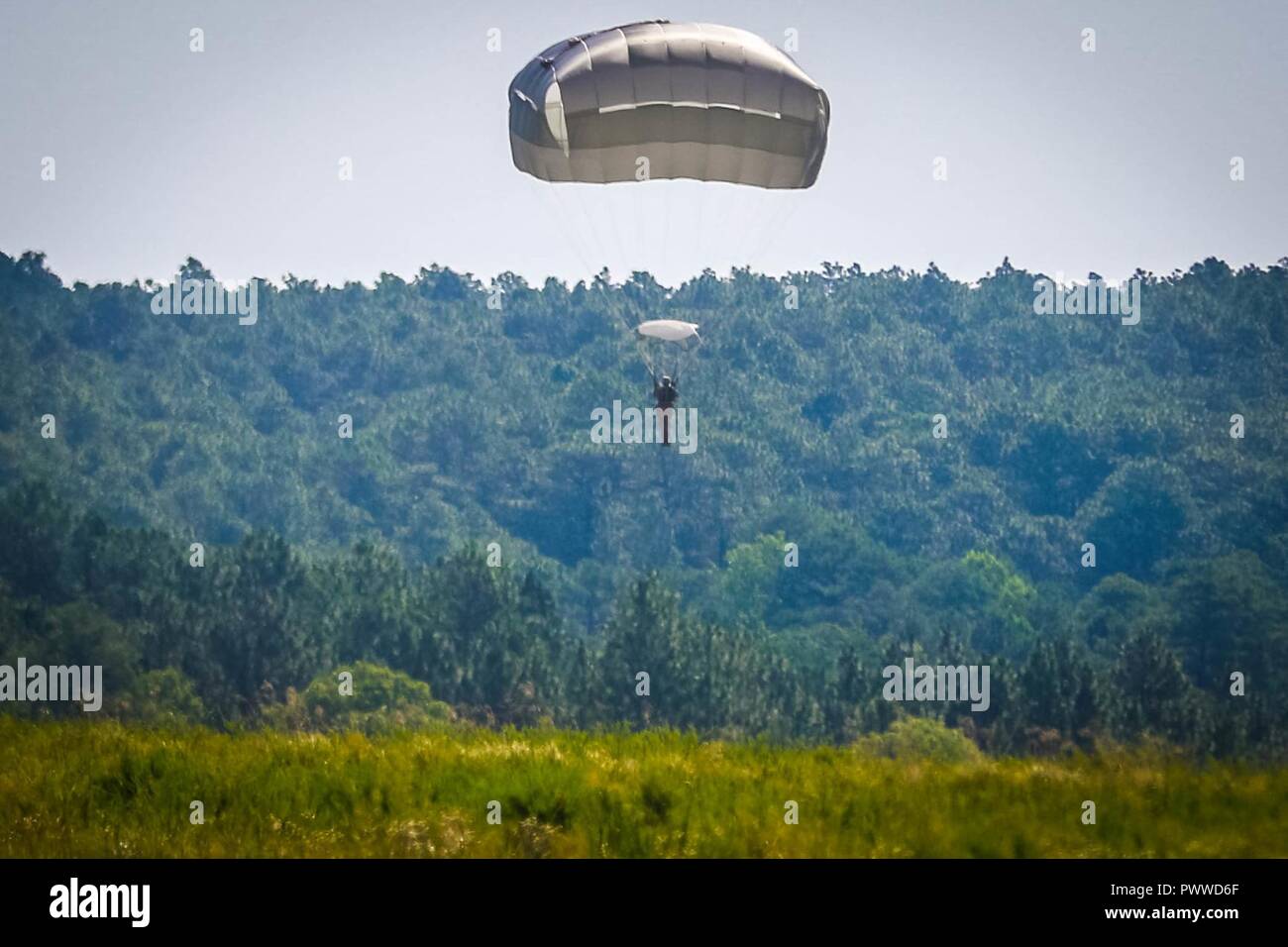 Un soldat affecté au 2e Bataillon, 505ème régiment de parachutistes, 3e Brigade Combat Team accolades avant l'atterrissage au cours d'une aile rotor sauter d'un hélicoptère CH-47 Chinook au sein du 3e Bataillon de l'aviation d'appui général, 82e Brigade d'aviation de combat, l'opération aéroportée sur Sicile Drop Zone à Fort Bragg, N.C., 6 juillet 2017. Banque D'Images