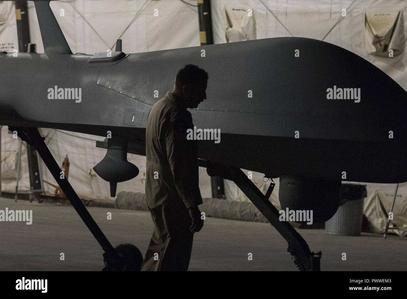 Le lieutenant-colonel Douglas, 361e Escadron d'attaque, le commandant de la Force expéditionnaire du Canada inspecte un prédateur MQ-1B après son dernier vol de combat affecté à la 361e EATKS, Juillet 2, 2017, dans le sud-ouest de l'Asie. Dans les 18 mois, le MQ-1B a été affecté à la 361e Escadron de reconnaissance de la force expéditionnaire, ultérieurement désigné comme le 361EATKS, son équipage a effectué l'avion sur plus de 2 000 missions de combat, 36 000 heures de reconnaissance et d'attaque de persistance, et a tiré 358 missiles AGM-114 Hellfire, contribuant considérablement à la lutte contre l'ISIS. Banque D'Images