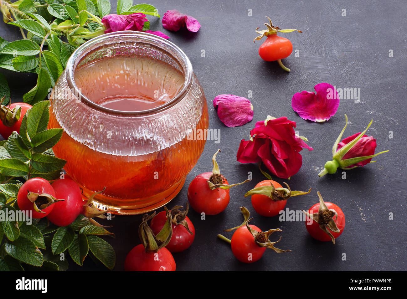 Un pot de confiture de rose sauvage, près de les baies et les bourgeons de la plante. Banque D'Images