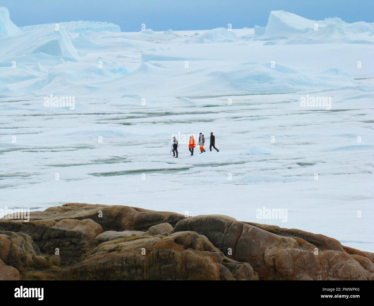 Les gens, les scientifiques, les chercheurs sont sur la montagne de pierre. Près de la rive de l'océan et des icebergs. L'antarctique. Banque D'Images