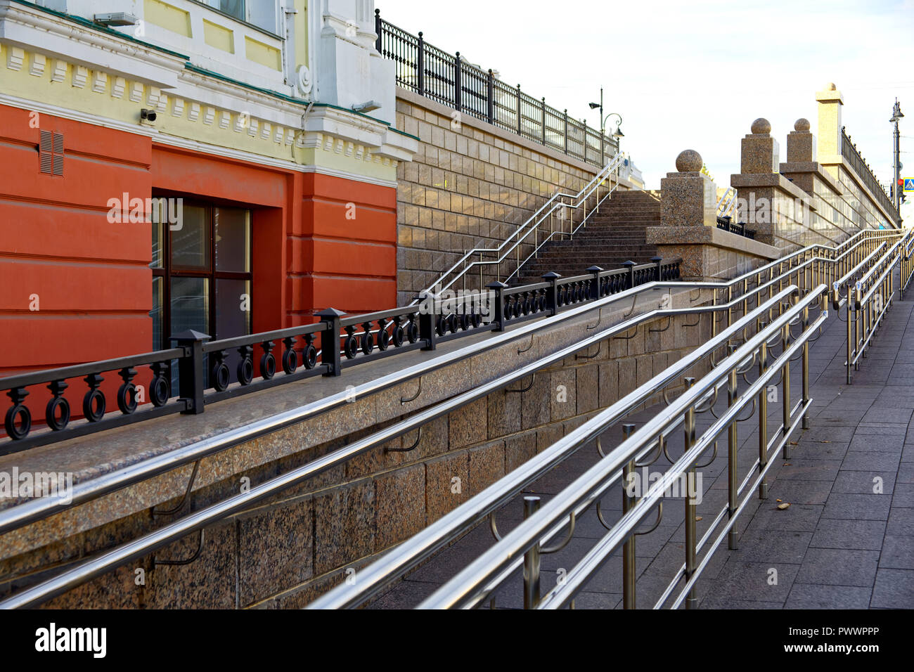 Omsk, Russie. Un grand, raide rampe pour fauteuil roulant à côté d'un escalier pour piétons régulièrement dans la partie centrale de la ville. La combinaison d'un 19e siècle Banque D'Images