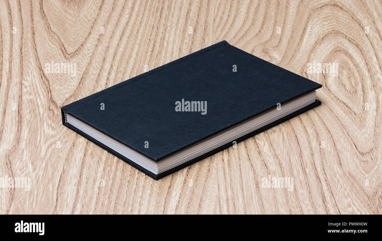 Black book on wooden table Banque D'Images