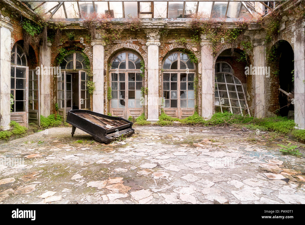 Grand piano brisé gisant sur le sol dans la cour d'un palais abandonné en Pologne. Banque D'Images