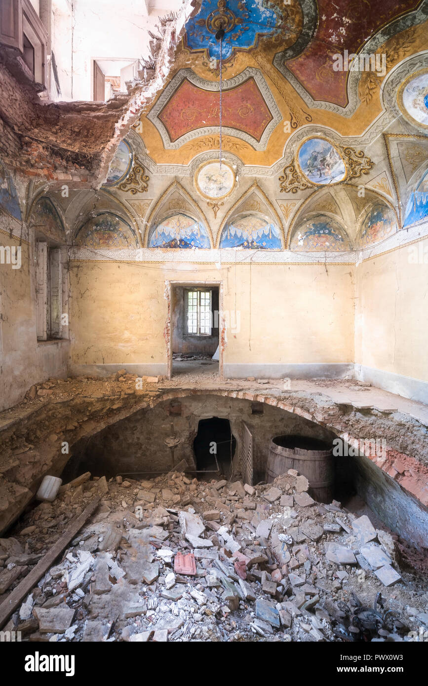 Vue intérieure d'une villa abandonnée avec des trous dans le sol en raison d'un tremblement de terre en Italie. Banque D'Images