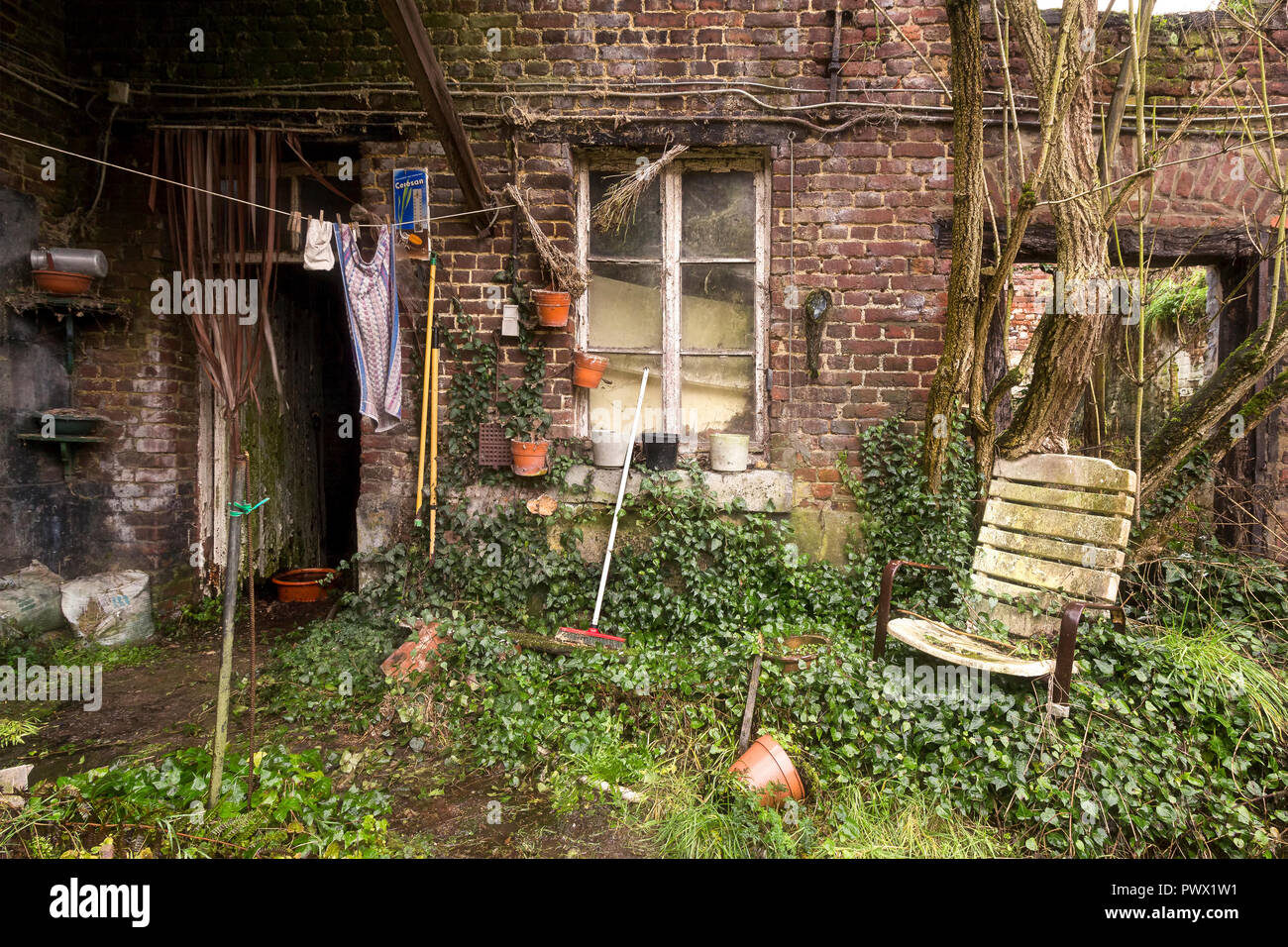Vue sur le jardin en face d'une maison abandonnée en Belgique. Banque D'Images