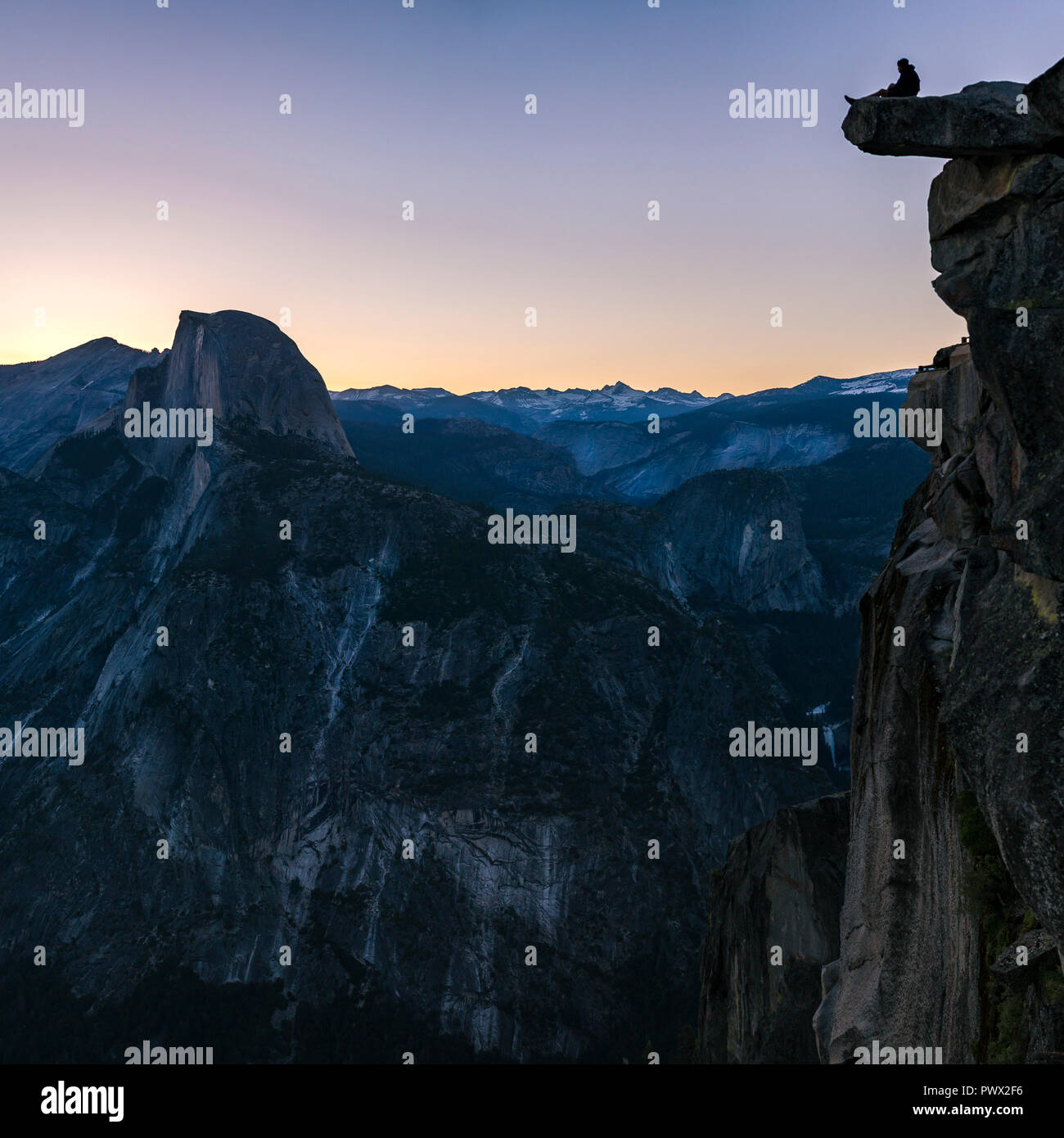 Homme assis au bord d'une falaise à Yosemite Banque D'Images