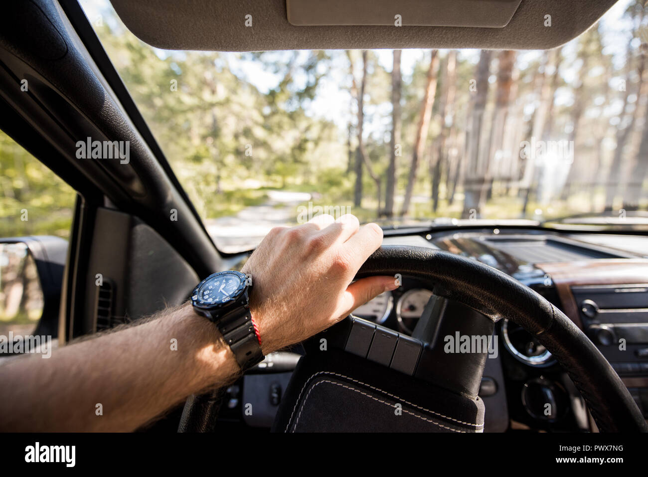 Portrait de l'homme à regarder la voiture conduite en forêt Banque D'Images